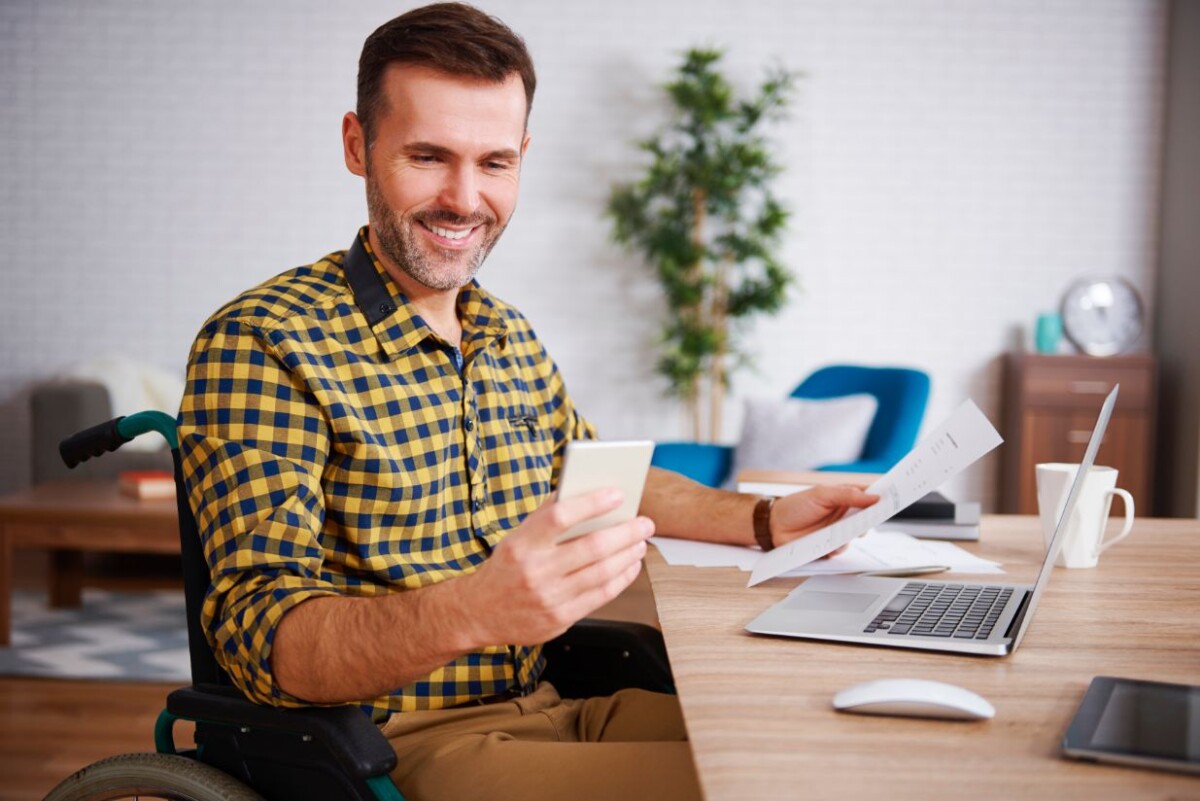 happy man on wheelchair working at home qvzd