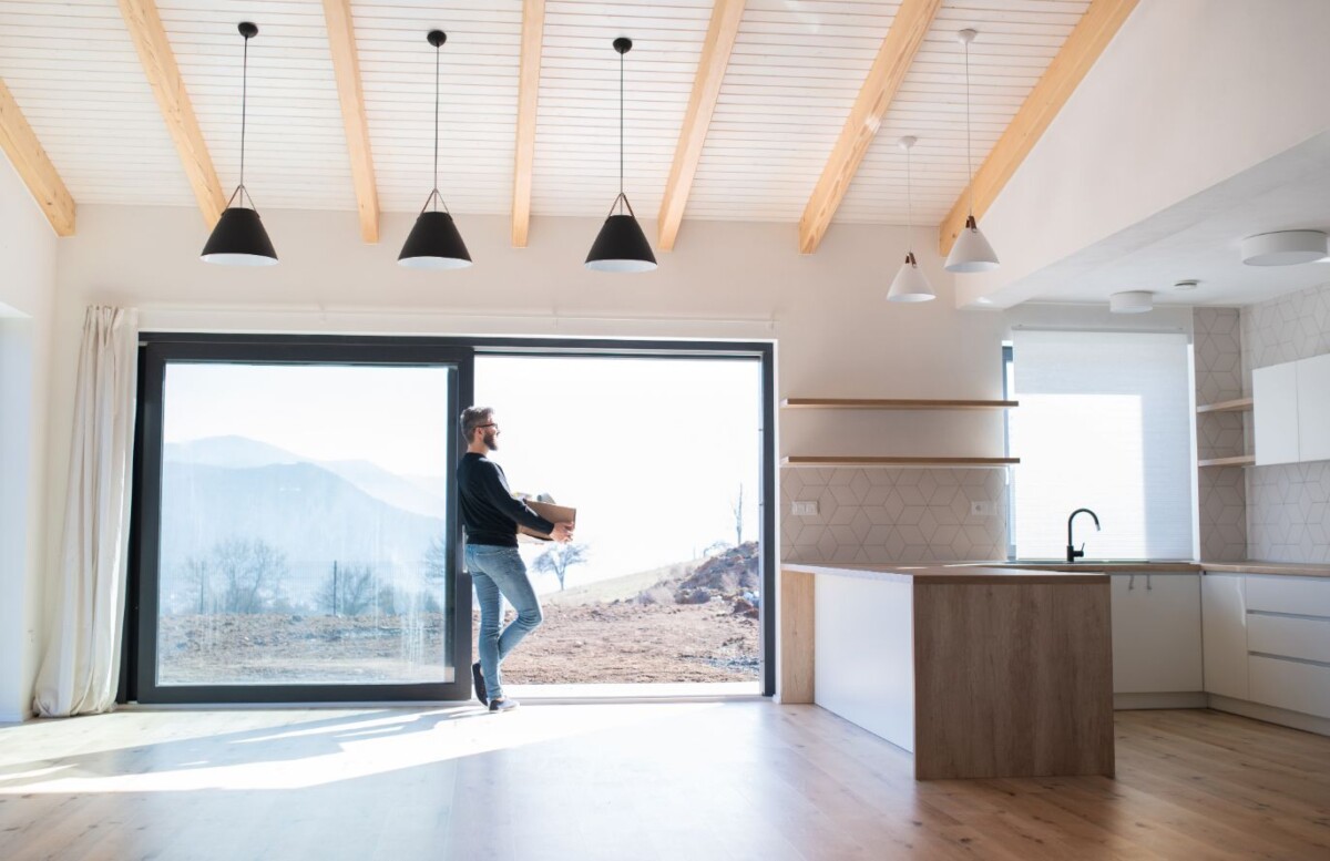 mature man with moving box standing by patio door ldau