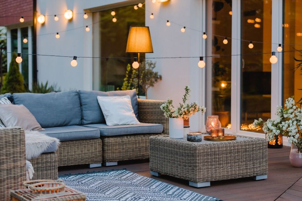 summer with patio with wicker furniture and lights tkdf