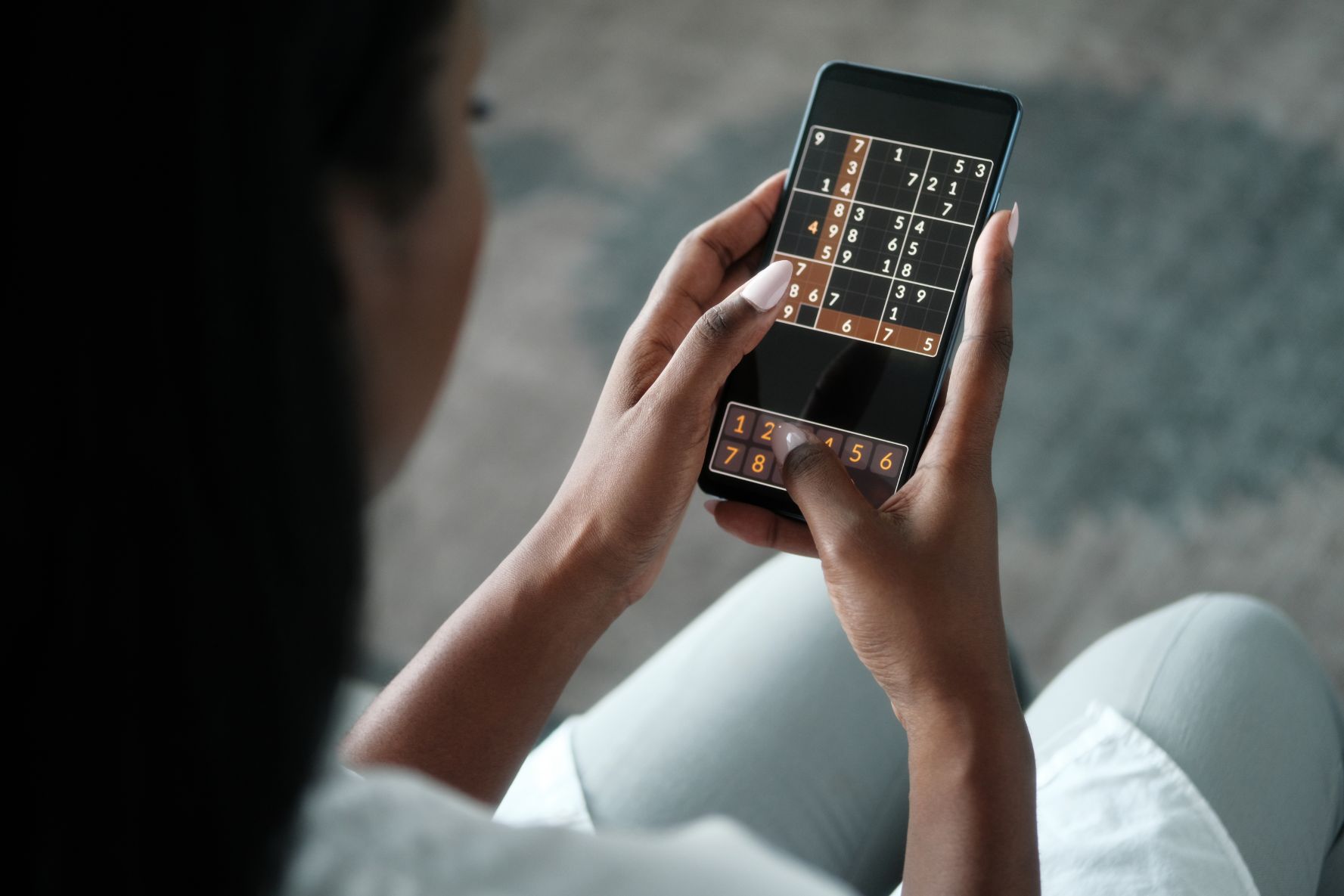 woman playing sudoku for brain training aar