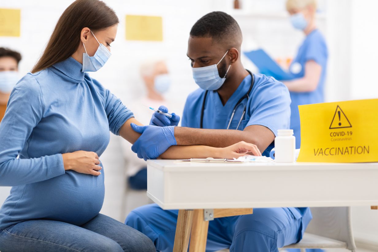 pregnant woman receiving coronavirus vaccine injec QMZYVD