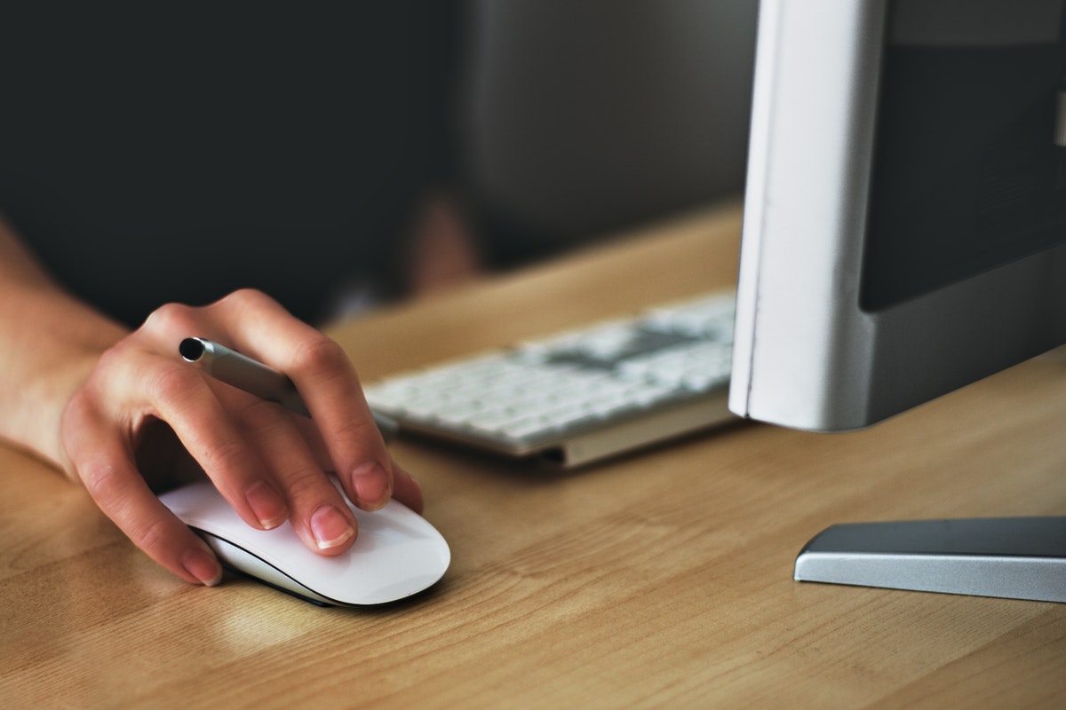 woman using computer mouse at her desk