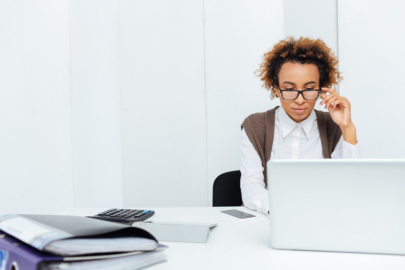 concentrated african american woman accountant working in office using laptop