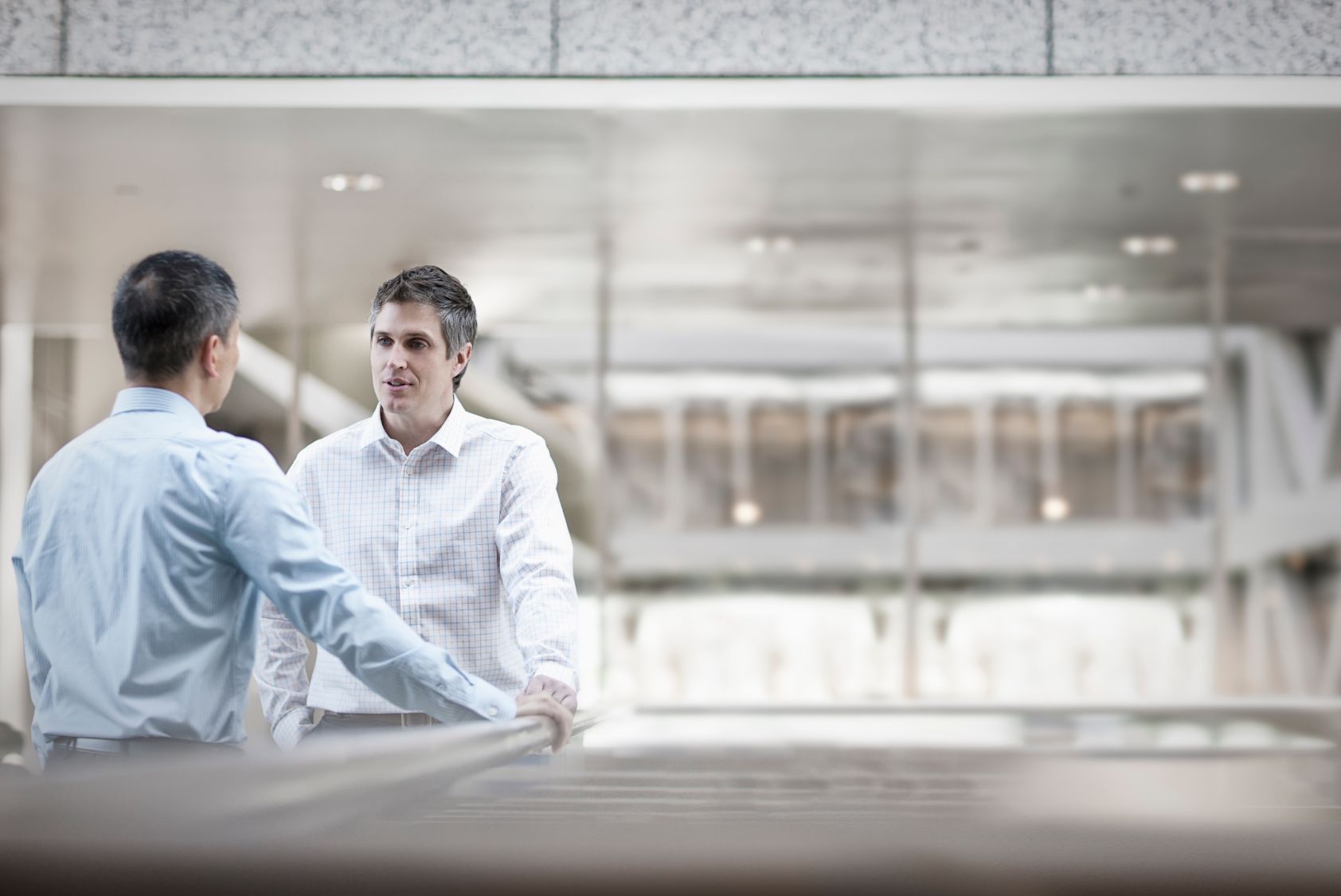 two men business colleagues standing talking SQUDDM