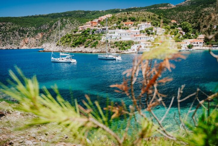Cozy colorful town Assos. Mediterranean sea and yacht sail boats. Kefalonia Island, Greece