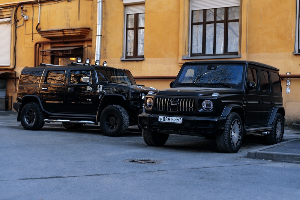 a black hummer and a black jeep parked in front of a building